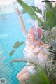 A woman in a bunny costume sitting by a pool.