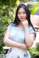 A woman in a blue and white dress posing for a picture.